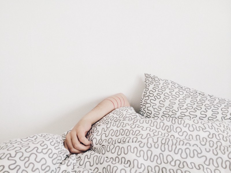 A person failed and exausted curled up in a cushion.
